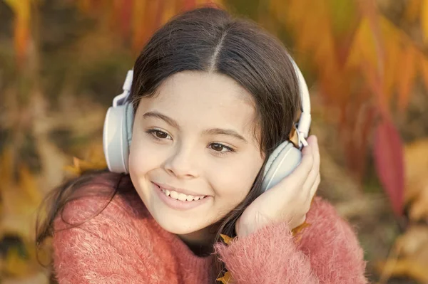 Koncepcja jesiennej playlisty. Ciesz się muzyką na świeżym powietrzu jesień ciepły dzień. Plik audio. Podcast edukacyjny. Poczuć radość. Kid girl relaks w pobliżu jesiennego drzewa ze słuchawkami. Muzyka na jesienny nastrój przytulny. Pieśń słuchania — Zdjęcie stockowe