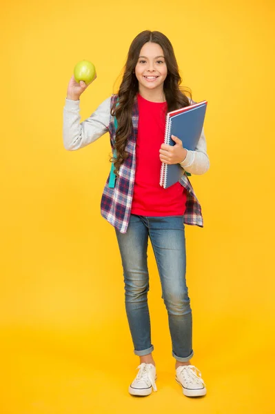 よく食べることはあなたの精神的な健康のために良い。幸せな子供はリンゴと本を保持します。脳の食物。自然食。歯の健康。歯の衛生だ。健康教育。学校の健康食品は本当にクールだ — ストック写真