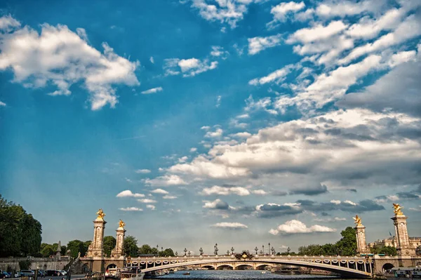 Paris, França - 01 de junho de 2017: ponte do convés sobre o rio Sena. Pont Alexandre III no céu azul nublado. Esculturas e arquitetura. Estilo arquitectónico. Património nacional. Monumento histórico. Viagens — Fotografia de Stock