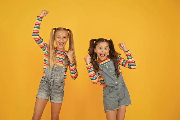 Tiene un gran estilo. Las hermanas pequeñas se divierten. niñas de fondo amarillo. peluquería. moda de verano niño. belleza y estilo. felicidad infantil. feliz amistad escolar. mejores amigos para siempre —  Fotos de Stock