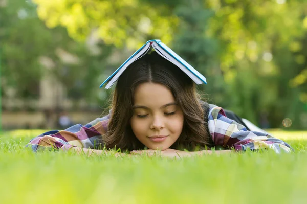 Beruhigendes Buch. Kleine Kinder schlafen auf grünem Gras. Bibliotherapie. Achtsamkeit und Entspannung. Mittagsschlaf. Zurück zur Schule. Nicht formale Bildung und Lernen. Entspannendes Buch für besseren Schlaf — Stockfoto