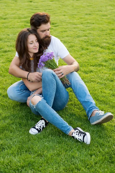 Pasangan baik hati berpelukan santai di padang rumput hijau, konsep hari para wanita — Stok Foto