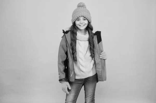 Ξέγνοιαστη παιδική ηλικία. Χαριτωμένο κορίτσι απολαμβάνουν τη χειμερινή περίοδο. Το μικρό παιδί φοράει πλεκτό καπέλο. Χειμερινές διακοπές. Προστατευτικά ρούχα. Χειμερινή συλλογή. Το παιδί φοράει μπουφάν με γάντια. Ενεργός ελεύθερος χρόνος. Αθλητικό στυλ — Φωτογραφία Αρχείου