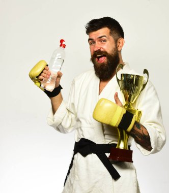 Boks eldivenli mutlu yüzlü karateci elinde şişe tutuyor.