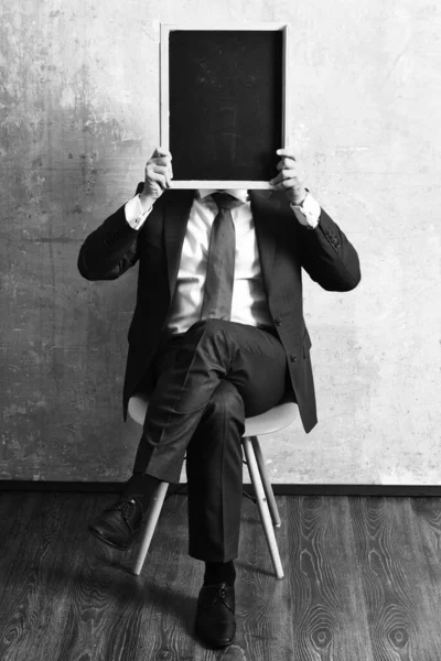 Hombre de negocios u hombre serio sosteniendo una pizarra — Foto de Stock