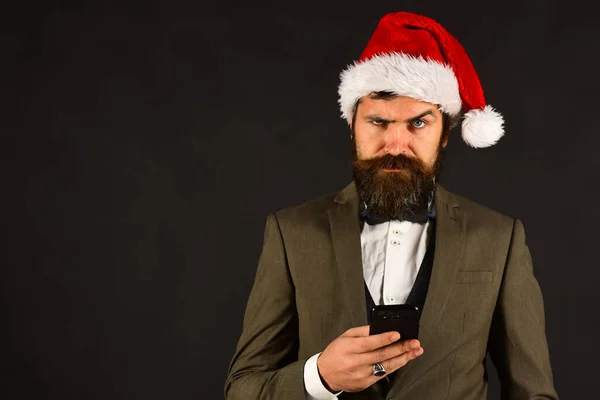 Manager with beard types message on cell phone