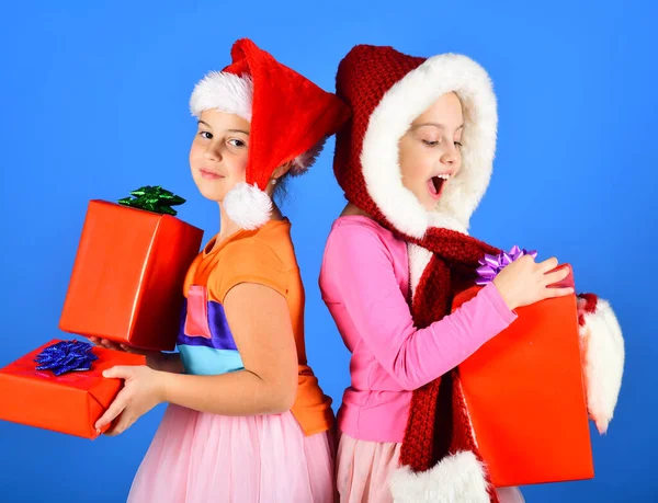 Les sœurs dans des chapeaux de Noël avec des boîtes-cadeaux reçoivent des cadeaux. — Photo