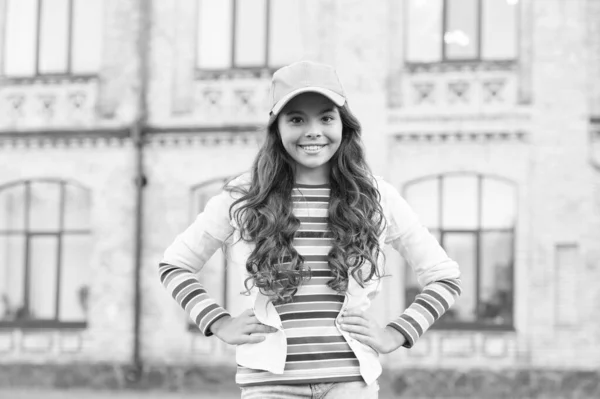 You would not know anything unless you try. Schoolgirl wear cap. Teen in casual style and cap. Childhood happiness. Happy girl with curly hair wearing cap. Child smiling outdoors. Beauty and fashion