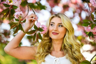 Bahar çiçeği açan ağaç. Bahar sembolü Çiçeklerin kadınları neden her zaman mutlu ettiğini. Mutlu bahar günleri. Kız bahçede sakura çiçeğinin tadını çıkarıyor. Kiraz ağacı. Çiçek aroması. Uyum ve kadın enerjisi.