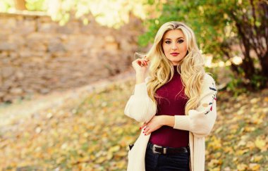 Uzun saç bakım konsepti. Soğuk sarışın konsepti. Saçları ne kadar hızlı ve güvenli bir şekilde beyazlatılmış. Sonbahar parkında şık sarışın kız yürüyüşü. Kıvırcık saçlardan kaçınmak için sonbahar saç bakımı önemlidir.