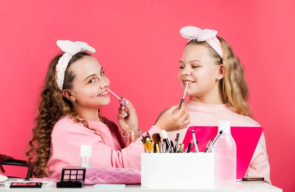 Cosmetics shop. Hobby and fun. Cosmetics for children. Spa party. Beauty salon. Sisterhood happiness. Skin care. Kids makeup. Beauty and fashion. Happy girls doing makeup. Sisters play with cosmetics