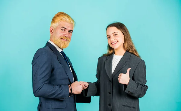 Business success. family business. partnership. teamwork of daughter and dad. business meeting. modern office life. businessman dyed blond hair. small girl in oversized suit jacket. future career