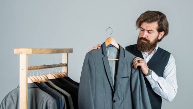 Doğru kararı bulmaya çalışıyorum. Sakallı adam, terzi kıyafetleri. Resmi ve ofis kıyafetleri. Kendine güvenen terzi erkek ceketi tasarlıyor. Mezura takan yakışıklı bir sartor. Erkek güzelliği ve moda