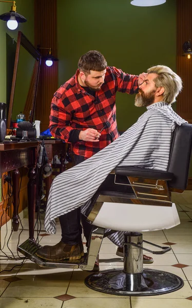 Fresco e alla moda. Parrucchiere in barbiere. uomo in parrucchiere con taglio di capelli hipster. barba e baffi. Parrucchiere professionista in interni di barbiere. Ritratto di uomo alla moda barba. rasatura — Foto Stock