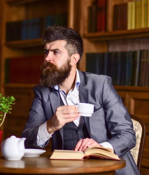 Uomo d'affari seduto nel caffè e bere il tè durante la lettura del libro — Foto Stock