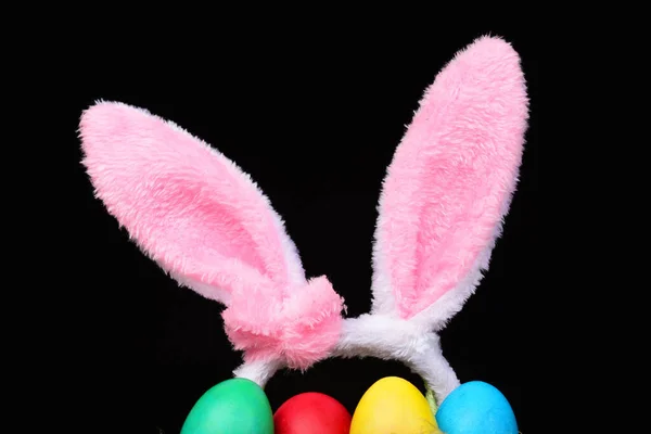 Pojęcie symboli wielkanocnych. Puszyste uszy królika z kolorowymi malowanymi jajami. — Zdjęcie stockowe