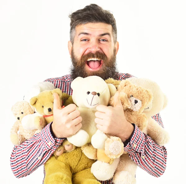Homem com cara feliz segura pilha de brinquedos macios. — Fotografia de Stock