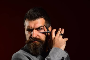 Koyu kırmızı arka planda ciddi yüzü olan bir iş adamı..