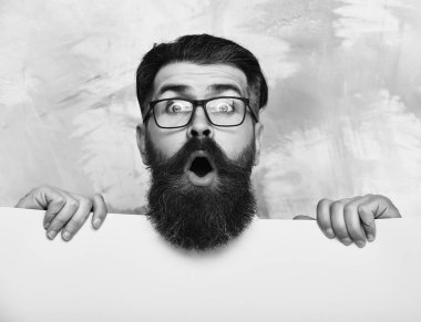 Renkli arka planda gözlüklü, şaşkın suratlı sakallı bir adam.