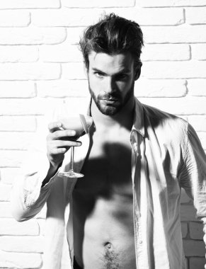 Beyaz tuğla duvarda yakışıklı, sakallı, maço seksi bir adam..