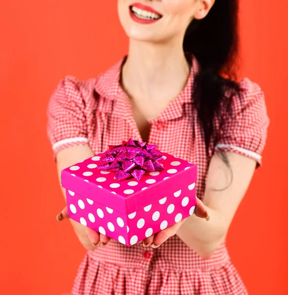 Pack et concept cadeau. Femme sourit et tient paquet cadeau rose vif. — Photo
