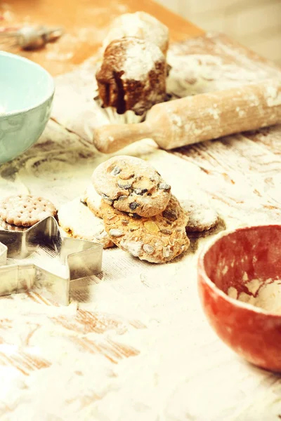 Ízletes csokoládé cookie-k fa asztalon sok liszt, szelektív fókusz — Stock Fotó