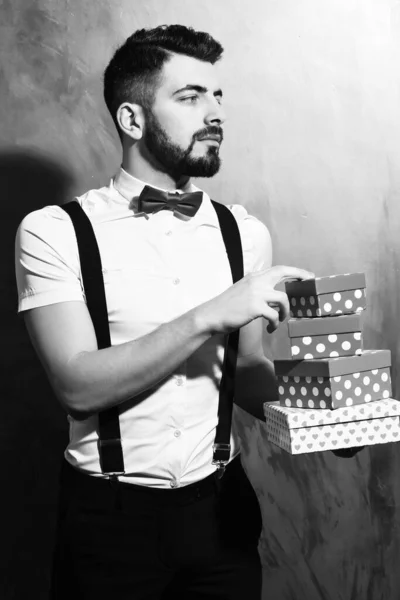 Bearded man holding present boxes with serious face — Stock Photo, Image