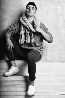 Gri süveter ve eşarplı yakışıklı genç adam.