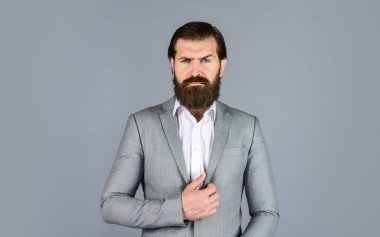 Pahalı takım elbiseli yakışıklı ve başarılı bir adam. O, beyaz gömlekli. Takım elbiseli başarılı bir adam. İş adamı takım elbise giyer. Resmi ofis hayatı. Ciddi sakallı adam. Yüz bakımı