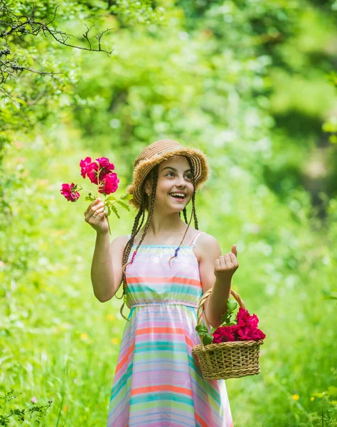 Composition des fleurs. Belle fille en chapeau de paille recueillir des roses. bonne enfance. belle fille avec des fleurs. petite fille tenant rose bouquet de fleurs fraîches en fleurs de roses — Photo