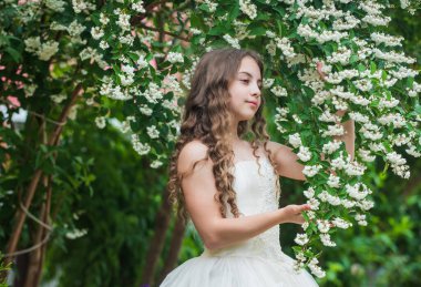 Muhteşem gelin kız beyaz elbise çiçekler açan arka plan, masumiyet konsepti.