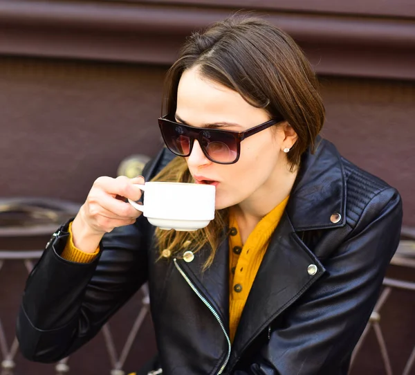 Menina em óculos de sol bebe café saboroso no terraço marrom — Fotografia de Stock