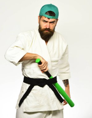 Katı yüzlü beyzbol oyuncusu yeşil beyzbol sopası tutuyor..