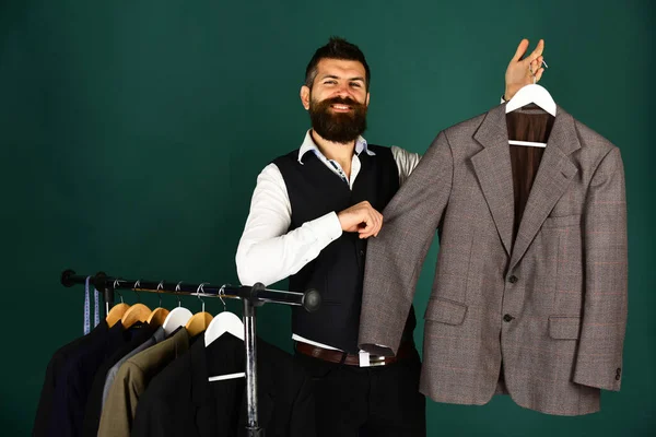 Дизайнер представляє куртку на вішалці для одягу. Людина з бородою — стокове фото