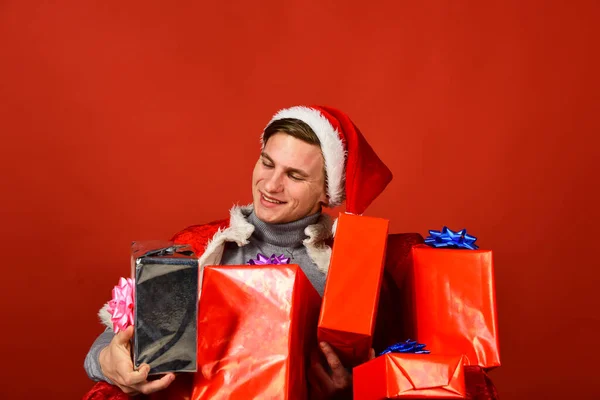 Santa con regalos sobre fondo rojo. El hombre tiene regalos de Navidad. — Foto de Stock