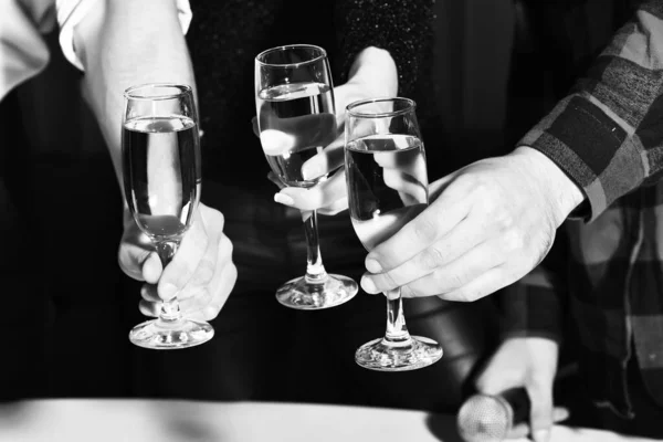 Vrouwelijke en mannelijke handen klinkende glazen met wijn — Stockfoto