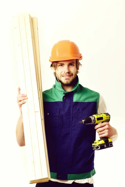 Construction worker holds wooden boards and yellow drill — Stock Photo, Image