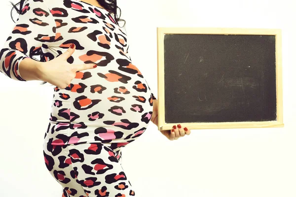 Mãos femininas de mulher grávida segurando placa preta — Fotografia de Stock