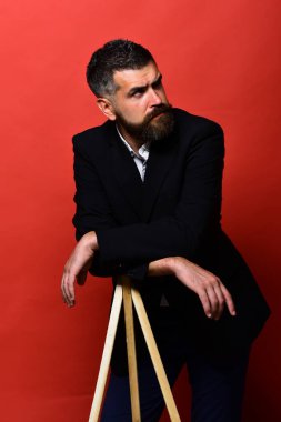 Sakallı ve bıyıklı adam klasik takım elbise giyiyor.