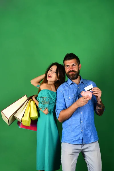 Casal apaixonado detém sacos de compras no fundo verde. — Fotografia de Stock