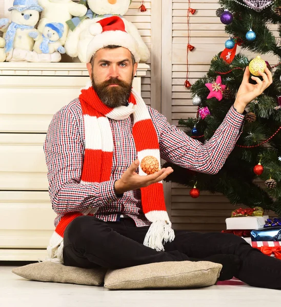 Guy in hat decorates firtree. Santa Claus with serious face — Stock Photo, Image