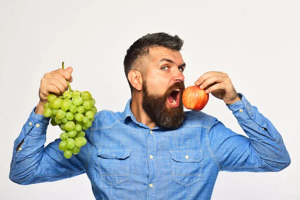 Οινοποιός με πεινασμένο πρόσωπο κρατά σταφύλια και φρούτα. — Φωτογραφία Αρχείου