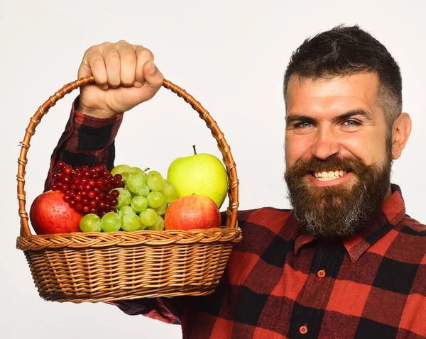 Άνδρας με χαμόγελο κρατά καλάθι με φρούτα σε λευκό φόντο. — Φωτογραφία Αρχείου