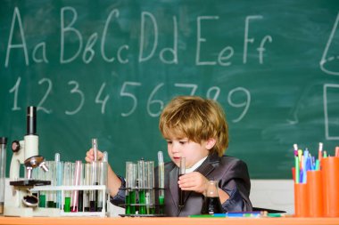 Küçük çocuk okulda kimya öğreniyor. Bilim okuyan okul çocuğu bilim adamı. İlkokuldaki küçük çocuk. Biyoloji okulu laboratuvar ekipmanları. Dersteki küçük çocuk araştırma yap.