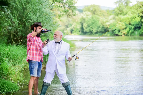 髭の男とエレガントなビジネスマンの釣りを一緒に。男は自然をリラックス背景。楽しさとリラックス。週末だ。釣りの技術。フックラインとシンカーでロッドを設定します。釣りやビールを飲む — ストック写真