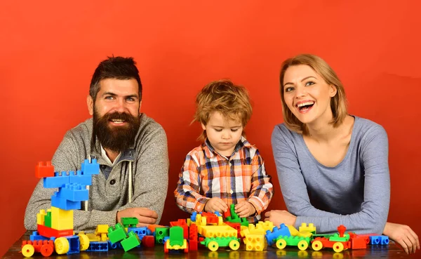 Man with beard, woman and boy play on red background
