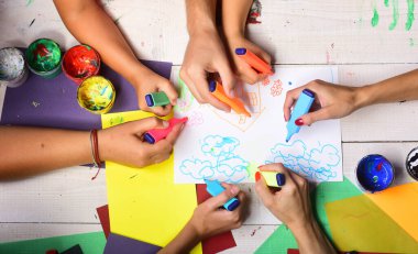 Sanatçılar boyalı ve renkli kağıtlı ahşap masa