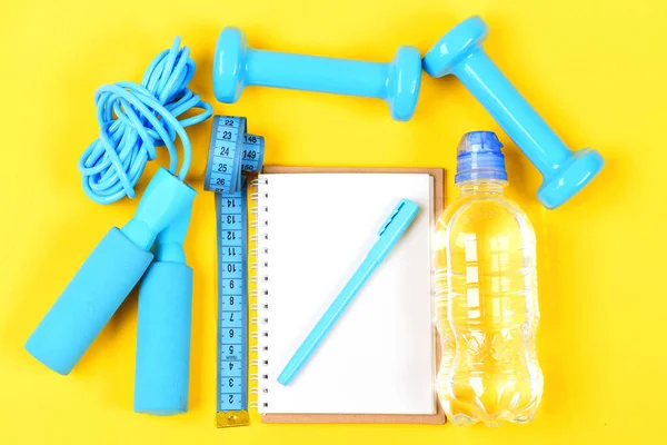 Notepad and fitness tools. Notebook, pen and gym equipment