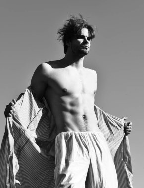 Mavi çizgili pijamalı, mavi güneşli arka planda beyaz maço.