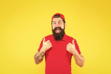 İşçi kiralamak. Hippi kasiyer. Teslimat servisi. Lokanta çalışanları aranıyor. Sakallı, hippi dövmeli, kasiyer üniformalı, sarı arka planlı bir adam. Kasiyer konsepti. Satıcı kasiyer kariyeri